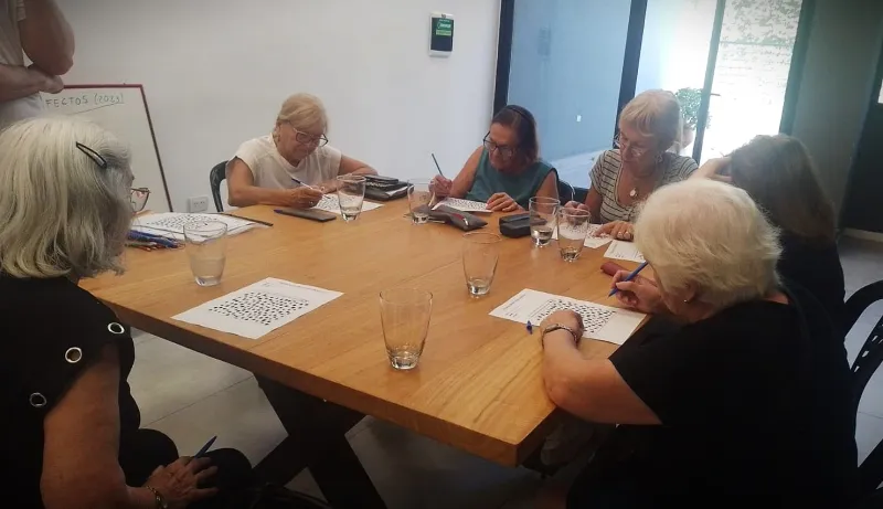 Grupo de alumnas resolviendo consignas escritas alrededor de la mesa de trabajo